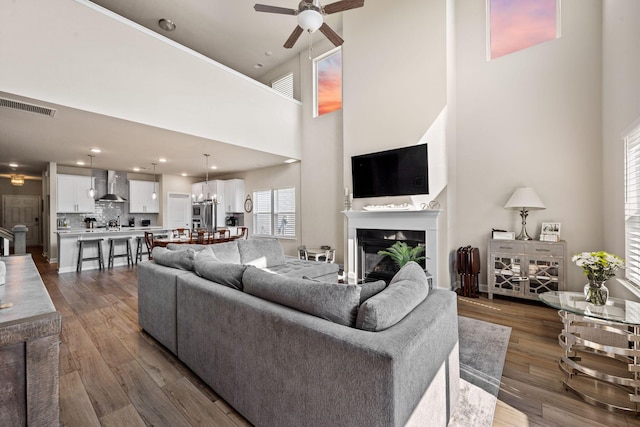 291 Lucca Dr, Summerville, SC 29486 - living room with a ceiling fan, a glass covered fireplace, a high ceiling, and dark wood-style flooring