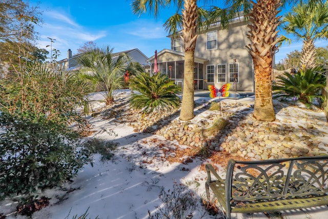 yard covered in snow with a sunroom