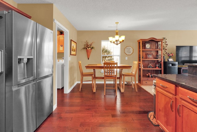 kitchen featuring stainless steel refrigerator with ice dispenser, washer / dryer, a chandelier, dark hardwood / wood-style flooring, and pendant lighting