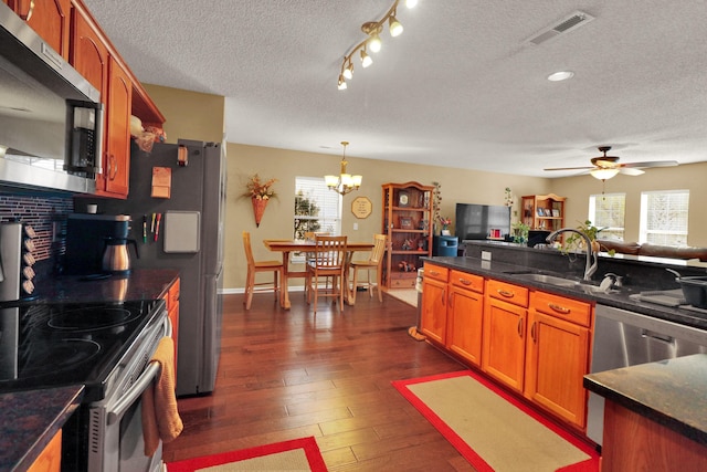 kitchen featuring sink, hanging light fixtures, stainless steel appliances, dark hardwood / wood-style flooring, and decorative backsplash