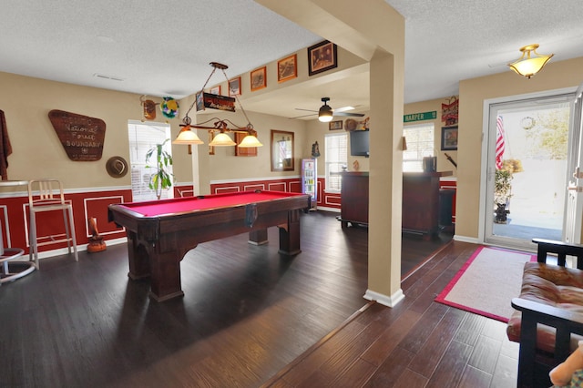 game room with plenty of natural light, dark wood-type flooring, pool table, and a textured ceiling