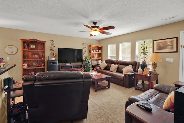 carpeted living room featuring a textured ceiling and ceiling fan