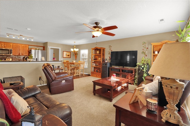 living room with light carpet, ceiling fan with notable chandelier, and a textured ceiling