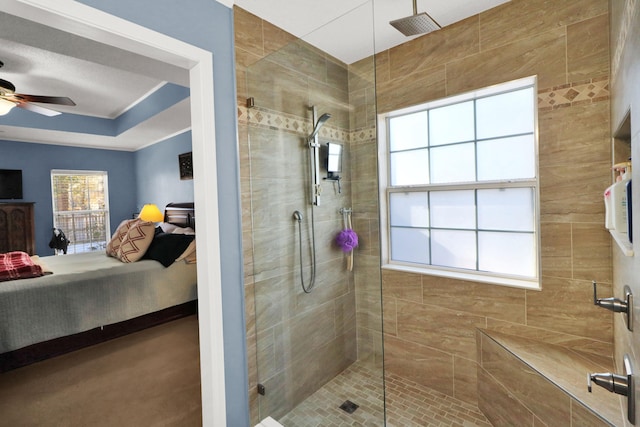 bathroom with ceiling fan and tiled shower