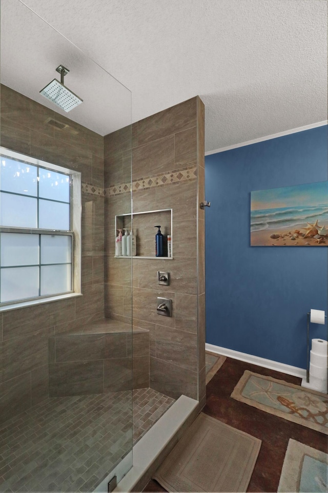 bathroom featuring a tile shower and a textured ceiling