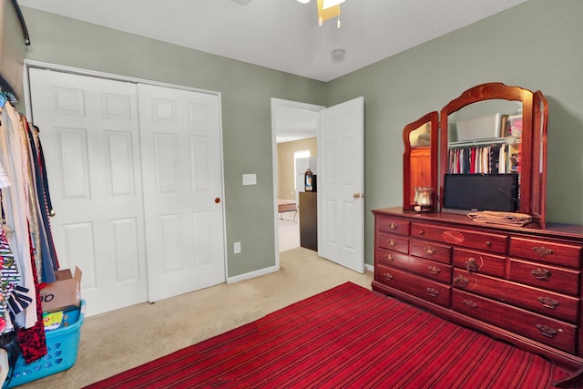 bedroom featuring light carpet, a closet, and ceiling fan