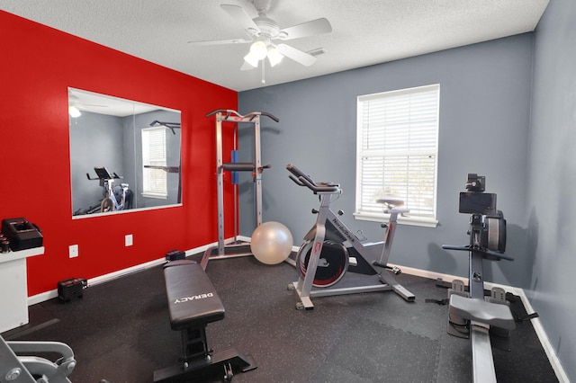 exercise area with ceiling fan and a textured ceiling