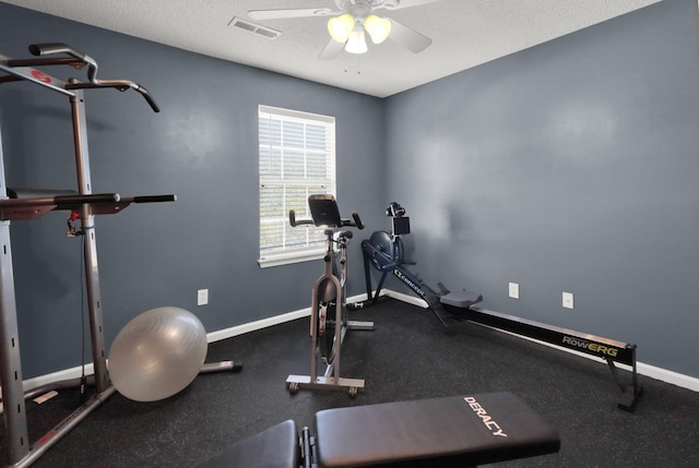 exercise area featuring ceiling fan and a textured ceiling