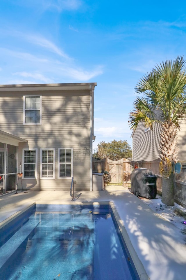 view of pool with grilling area and a patio