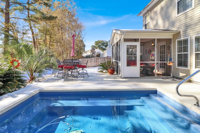 view of swimming pool featuring a patio area and a sunroom