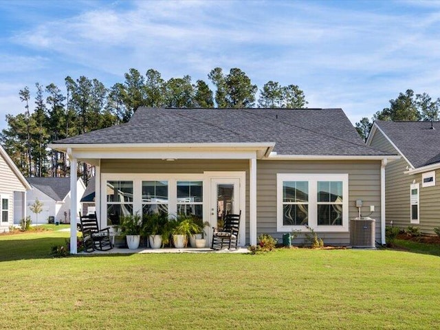 back of property with a yard and central AC unit