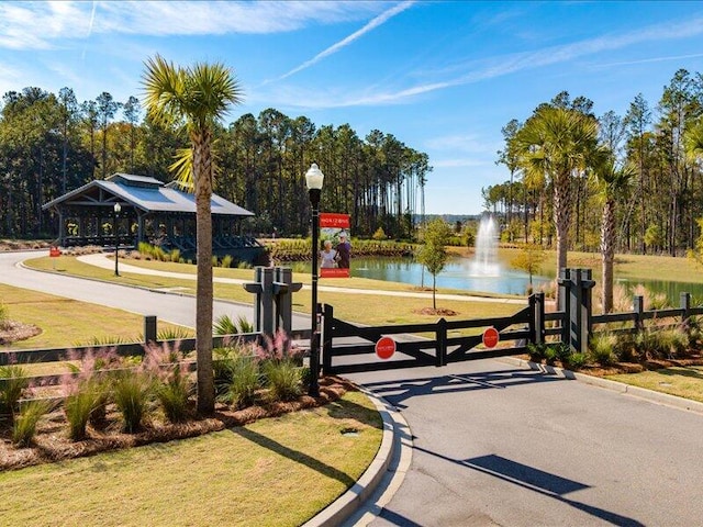 view of property's community featuring a water view and a lawn