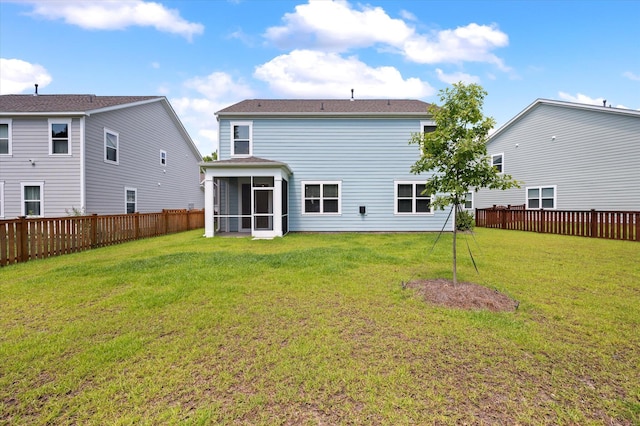 back of property with a sunroom and a yard