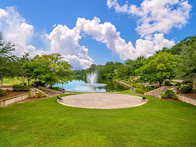 view of community with a water view and a lawn