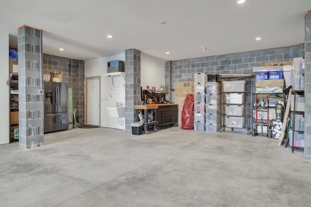 1821 Mead Ln, Johns Island, SC 29455 - garage featuring stainless steel fridge, concrete block wall, and recessed lighting