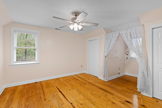 interior space with ceiling fan, wood-type flooring, and vaulted ceiling