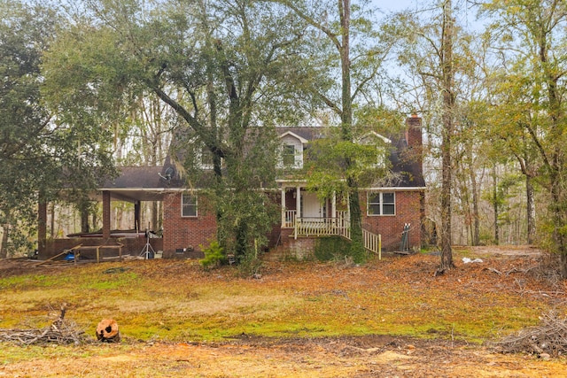 cape cod house with brick siding and a chimney