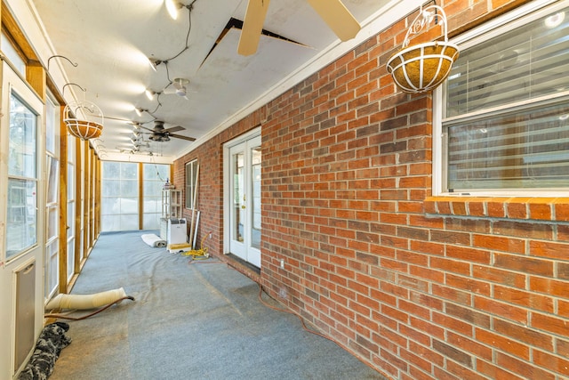 unfurnished sunroom featuring ceiling fan