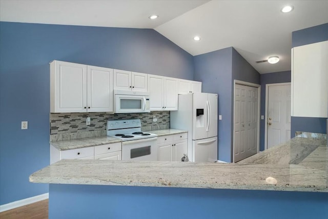 kitchen with tasteful backsplash, white appliances, white cabinets, and vaulted ceiling