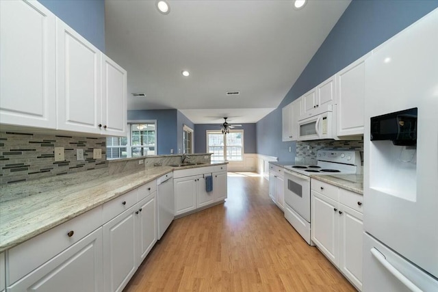 kitchen with white cabinets, a sink, ceiling fan, white appliances, and a peninsula