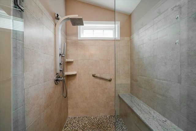 bathroom with vaulted ceiling and a tile shower