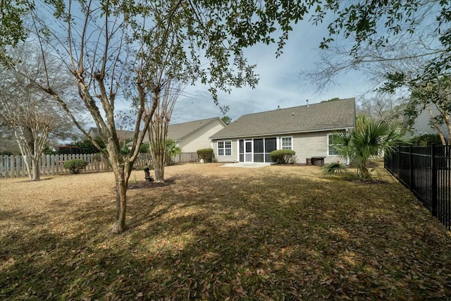 back of house featuring a sunroom, a fenced backyard, and a patio