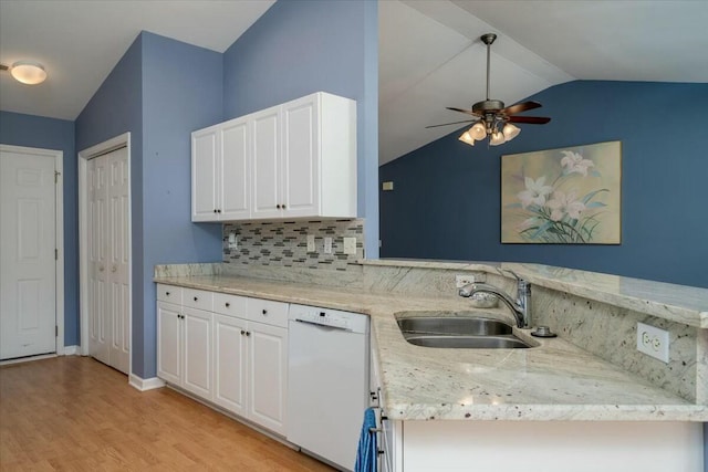 kitchen featuring lofted ceiling, white dishwasher, a sink, and white cabinetry