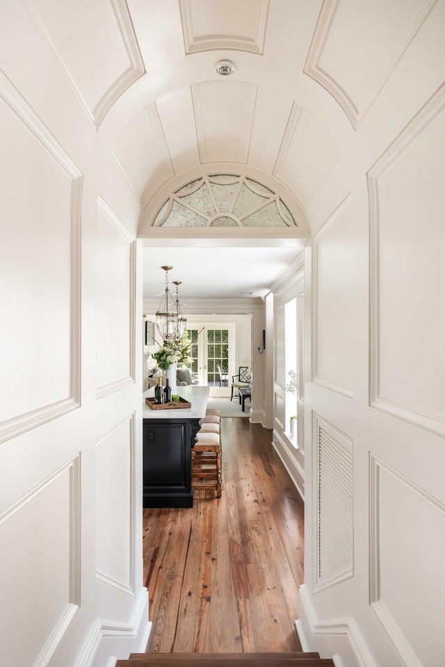 12 Orange St, Charleston, SC 29401 - corridor with lofted ceiling, a notable chandelier, crown molding, and hardwood / wood-style flooring