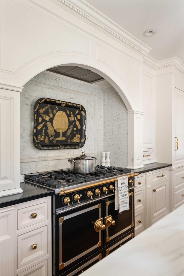 12 Orange St, Charleston, SC 29401 - kitchen with white cabinetry, double oven range, dark countertops, and arched walkways