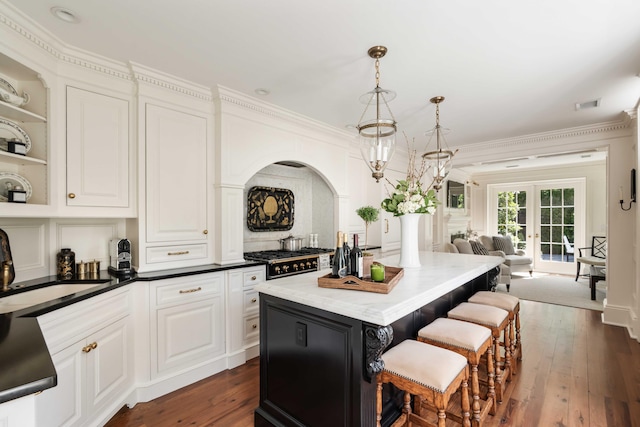12 Orange St, Charleston, SC 29401 - kitchen featuring a sink, a kitchen breakfast bar, a kitchen island, white cabinets, and dark wood-style floors