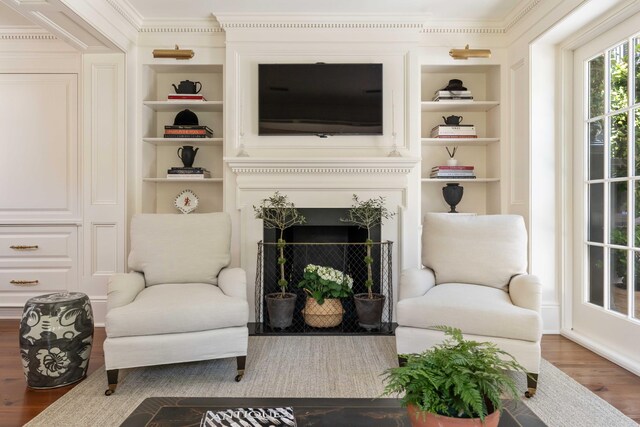 12 Orange St, Charleston, SC 29401 - sitting room featuring crown molding, built in features, wood finished floors, and a fireplace