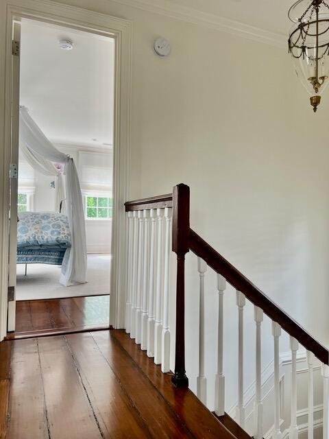 12 Orange St, Charleston, SC 29401 - staircase with crown molding, a chandelier, and wood finished floors