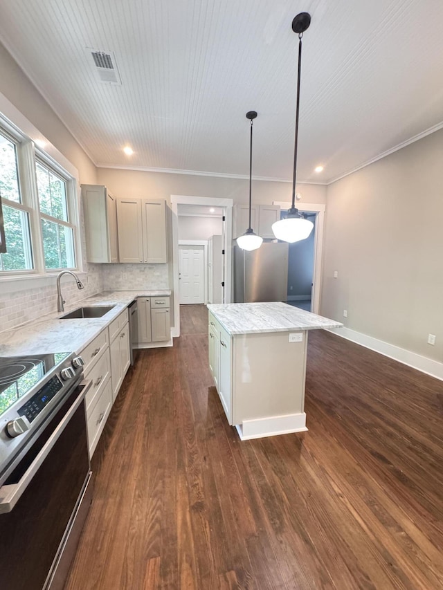 kitchen featuring decorative backsplash, dark wood-style floors, a center island, a sink, and stainless steel appliances