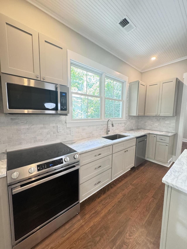 kitchen featuring visible vents, a sink, backsplash, and stainless steel appliances