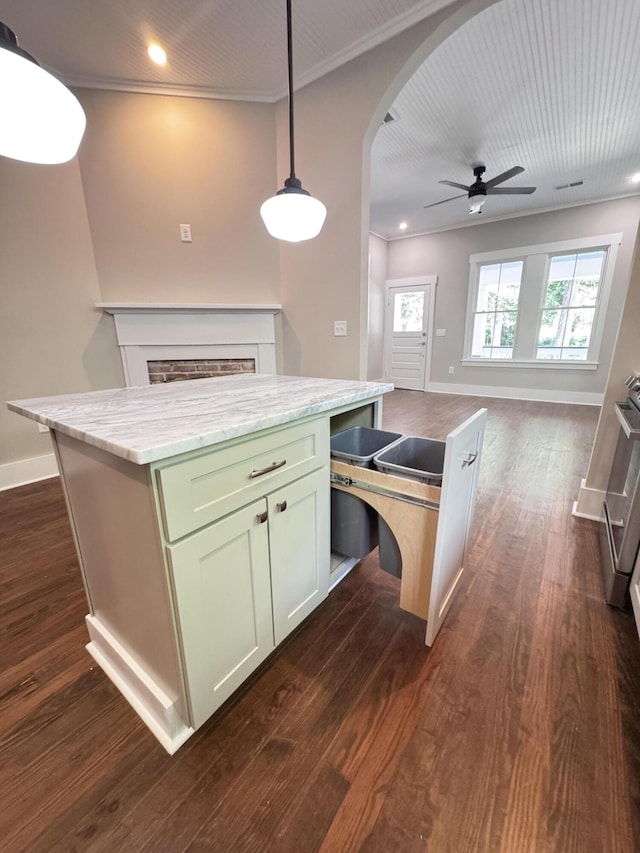 kitchen featuring ceiling fan, arched walkways, a center island, baseboards, and dark wood-style floors