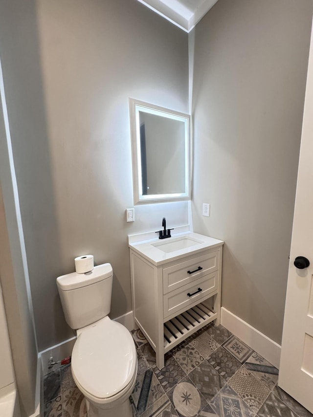 bathroom with baseboards, vanity, and toilet