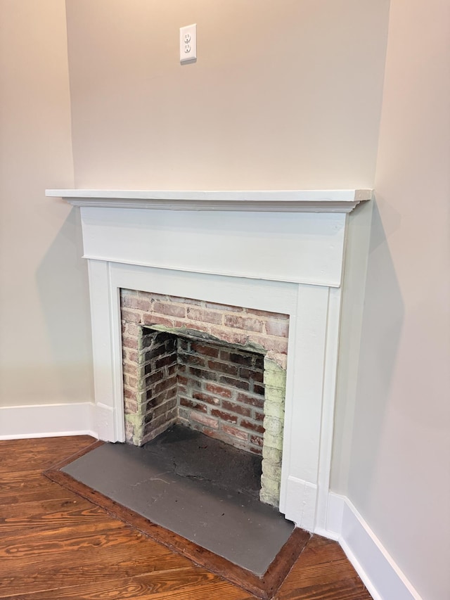 interior details featuring baseboards, a fireplace, and wood finished floors