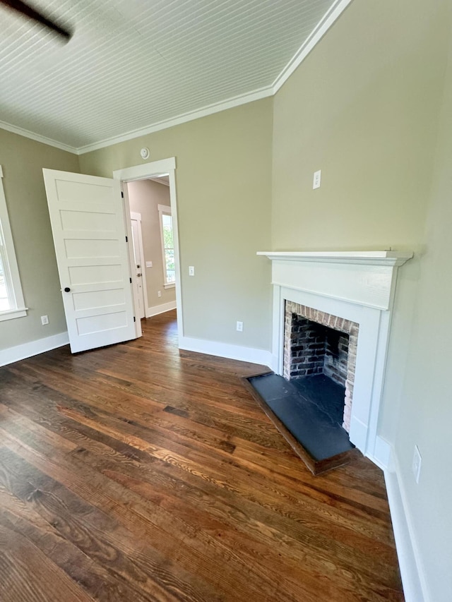 unfurnished living room featuring baseboards, ornamental molding, a fireplace, and wood finished floors