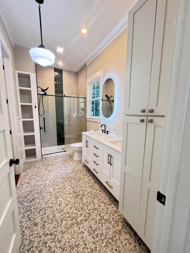 full bath with a sink, double vanity, toilet, recessed lighting, and a stall shower