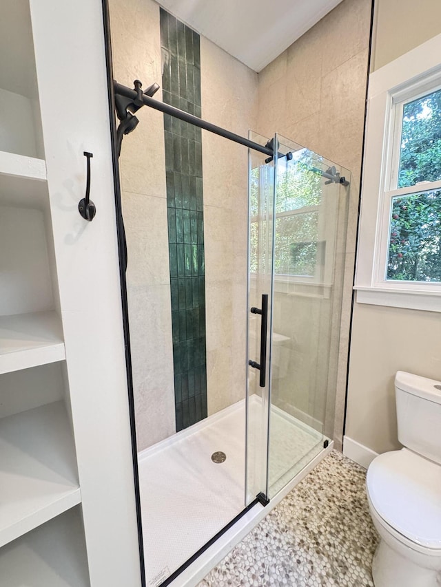 full bath featuring baseboards, toilet, and a shower stall