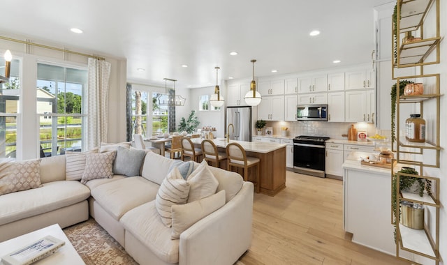 living room with light wood-type flooring and recessed lighting