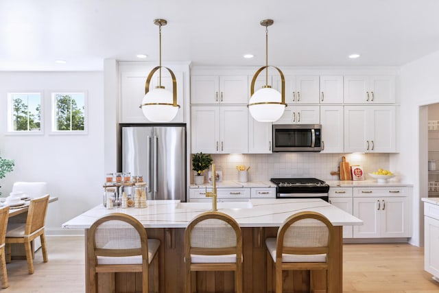 kitchen with light wood finished floors, stainless steel appliances, decorative backsplash, and light countertops