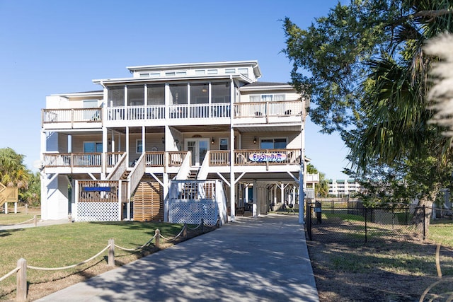 view of front of property featuring a sunroom, a carport, and a front yard