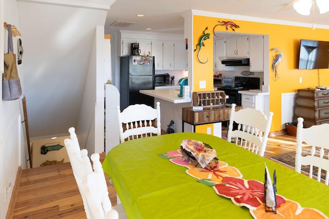 dining room featuring light hardwood / wood-style flooring, ceiling fan, and crown molding