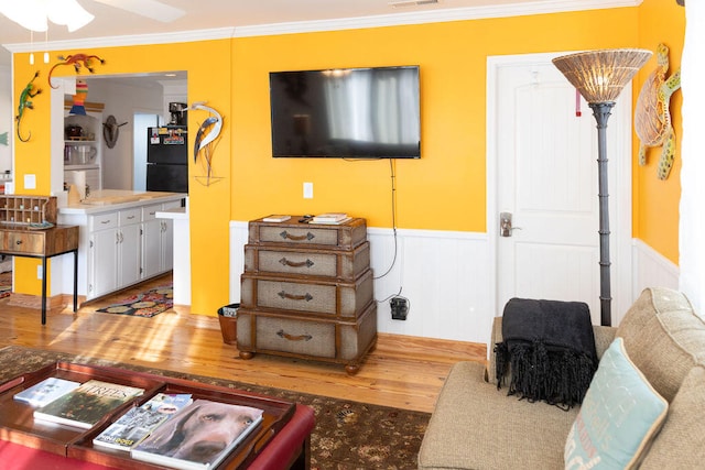 living room with ceiling fan, wood-type flooring, and crown molding