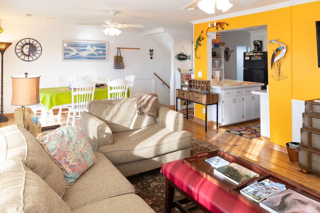 living room with hardwood / wood-style floors, ceiling fan, and ornamental molding