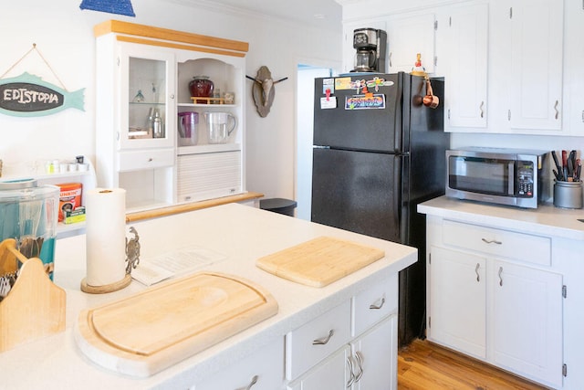 kitchen with crown molding, white cabinets, and light hardwood / wood-style floors