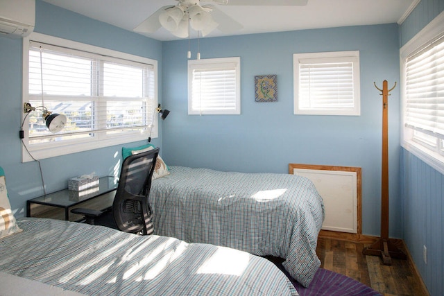 bedroom featuring dark hardwood / wood-style floors, ceiling fan, and an AC wall unit