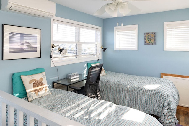 bedroom with hardwood / wood-style flooring, a wall mounted AC, and ceiling fan