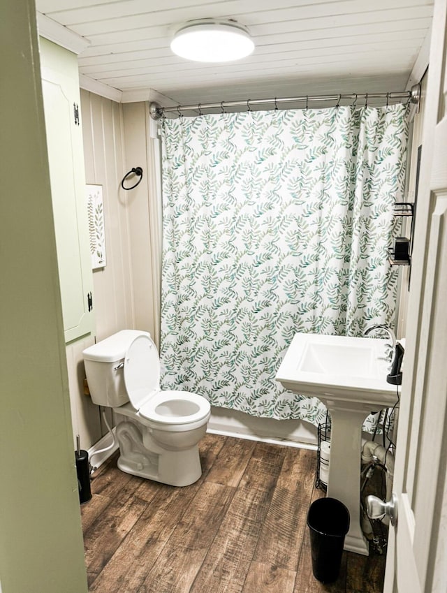 bathroom with hardwood / wood-style flooring, toilet, and shower / bath combo